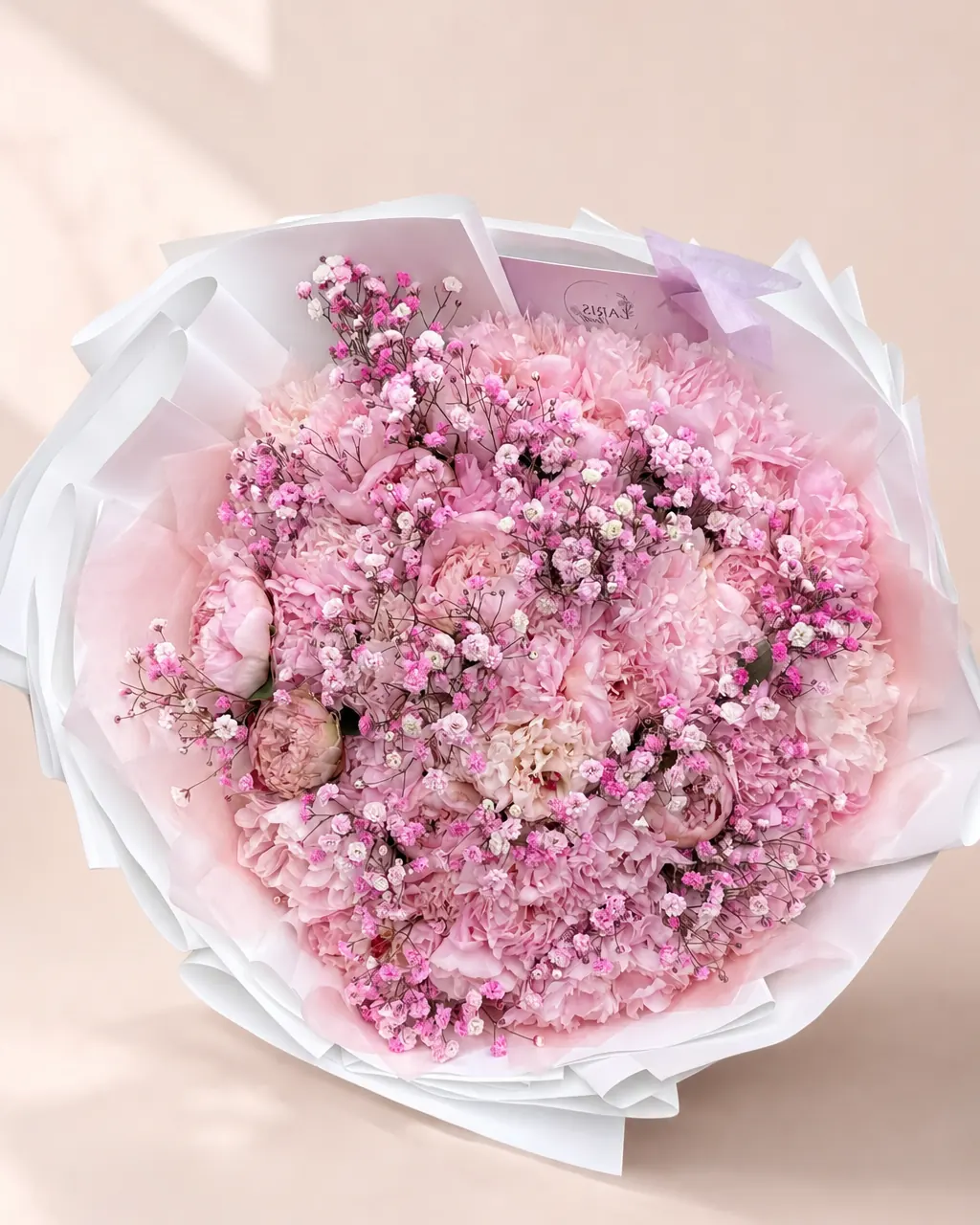 Sugared Peonies bouquet of fifty soft pink peonies scattered with pink baby's breath in white wrap