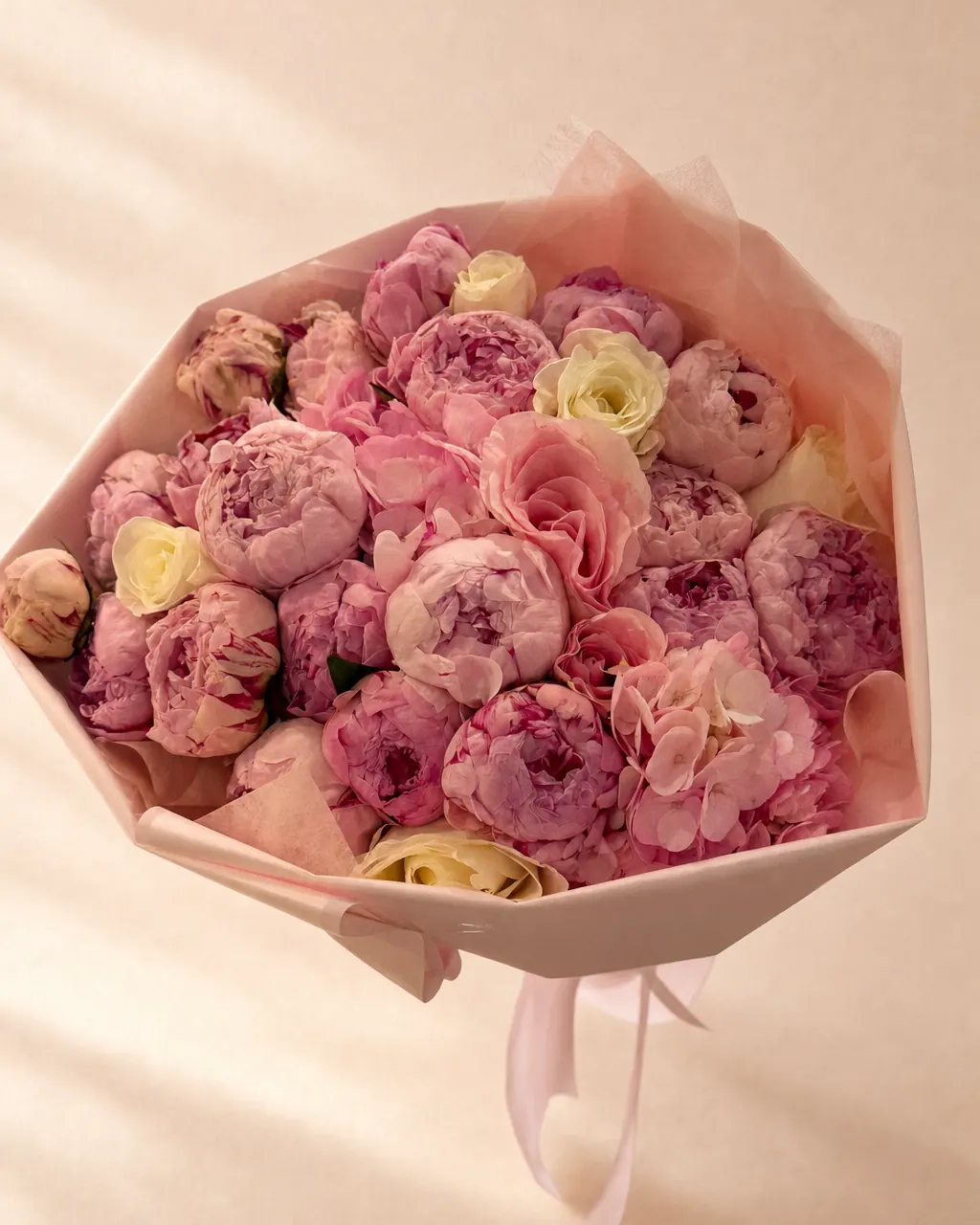 Peony Season bouquet of pink peonies with cream roses and pink hydrangea in blush wrap