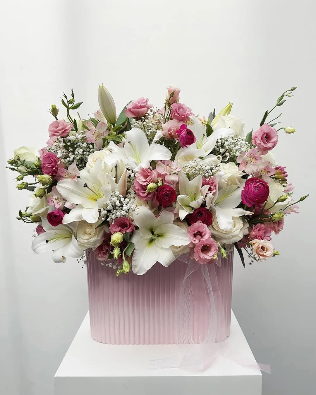 Luxury arrangement of white lilies, pink lisianthus and roses in a pink box