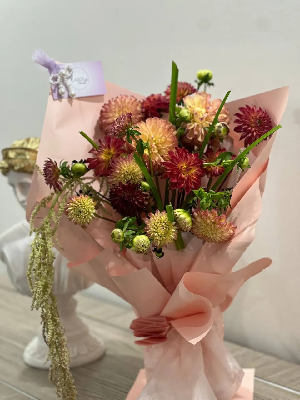 Autumn bouquet of burgundy and peach dahlias with craspedia and trailing amaranthus
