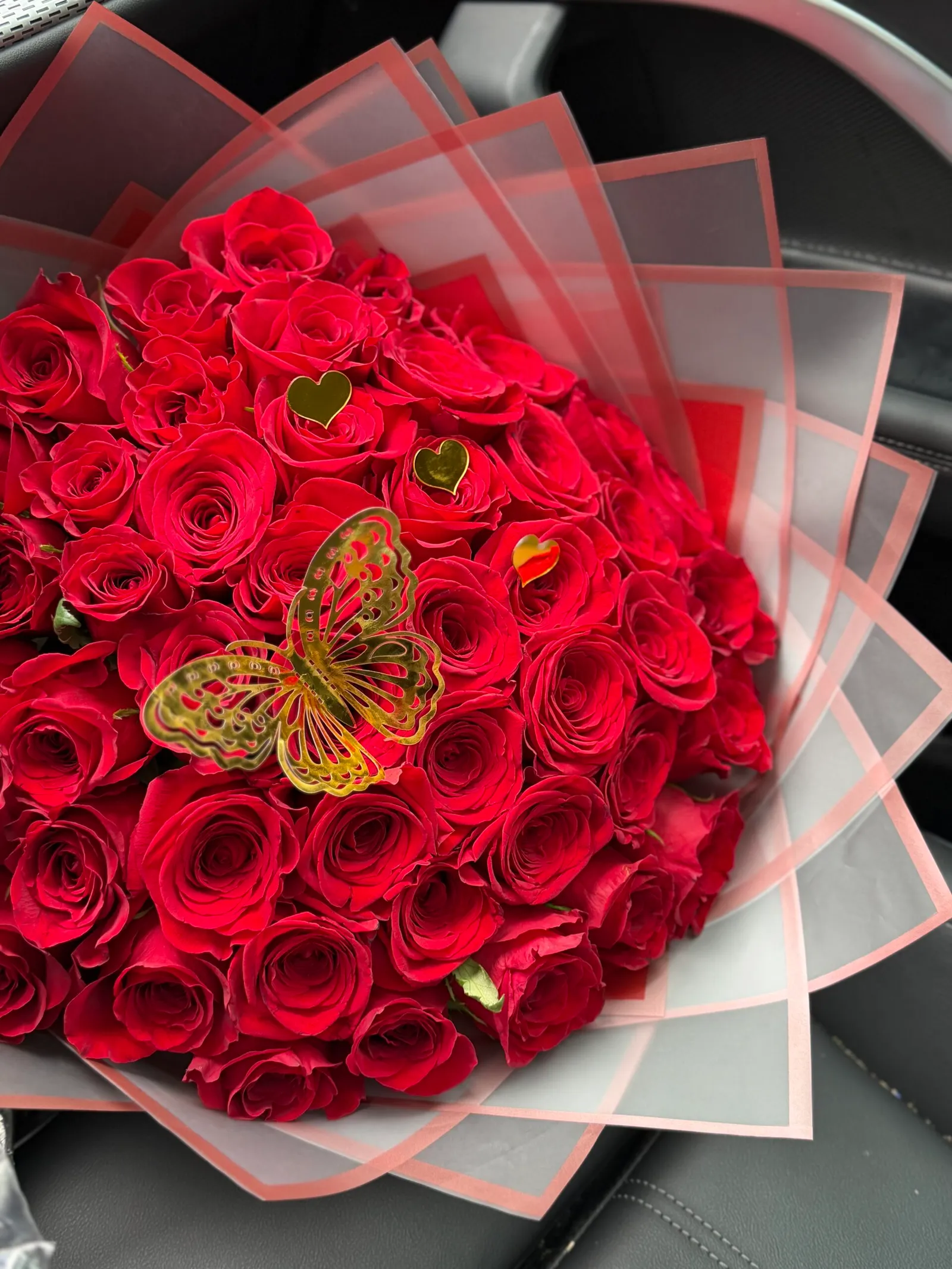 Round bouquet of red roses with gold heart accents