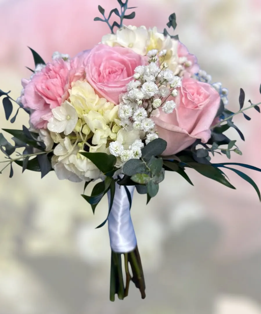 Bouquet of pink roses, white hydrangea and baby's breath with a white satin handle