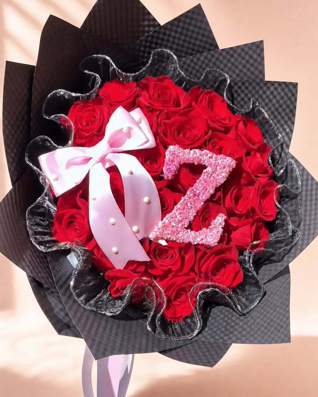 Ballet Bow: 25 red roses with an initial and a bow, photographed on a blush backdrop