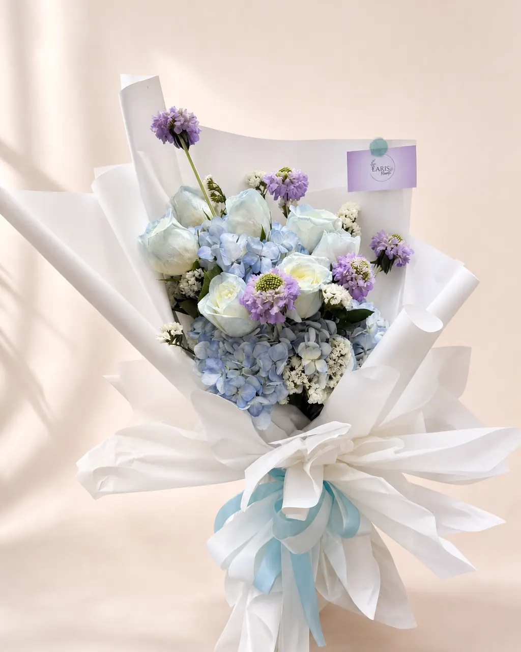 Blue Lullaby: Blue hydrangeas, roses and fillers, photographed on a blush backdrop