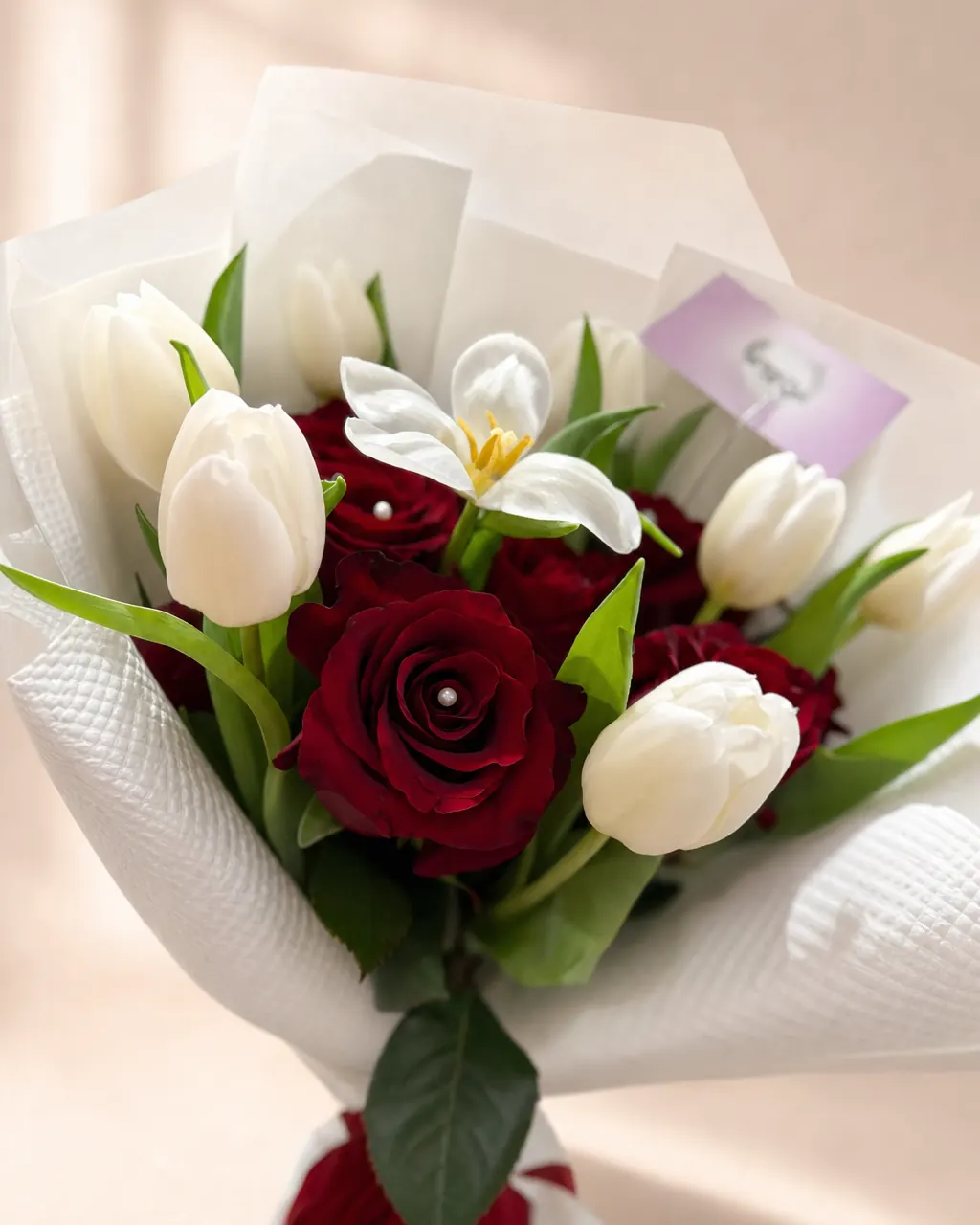 Claret Tulip: 12 red roses and 10 white tulips with pearl pins, photographed on a blush backdrop