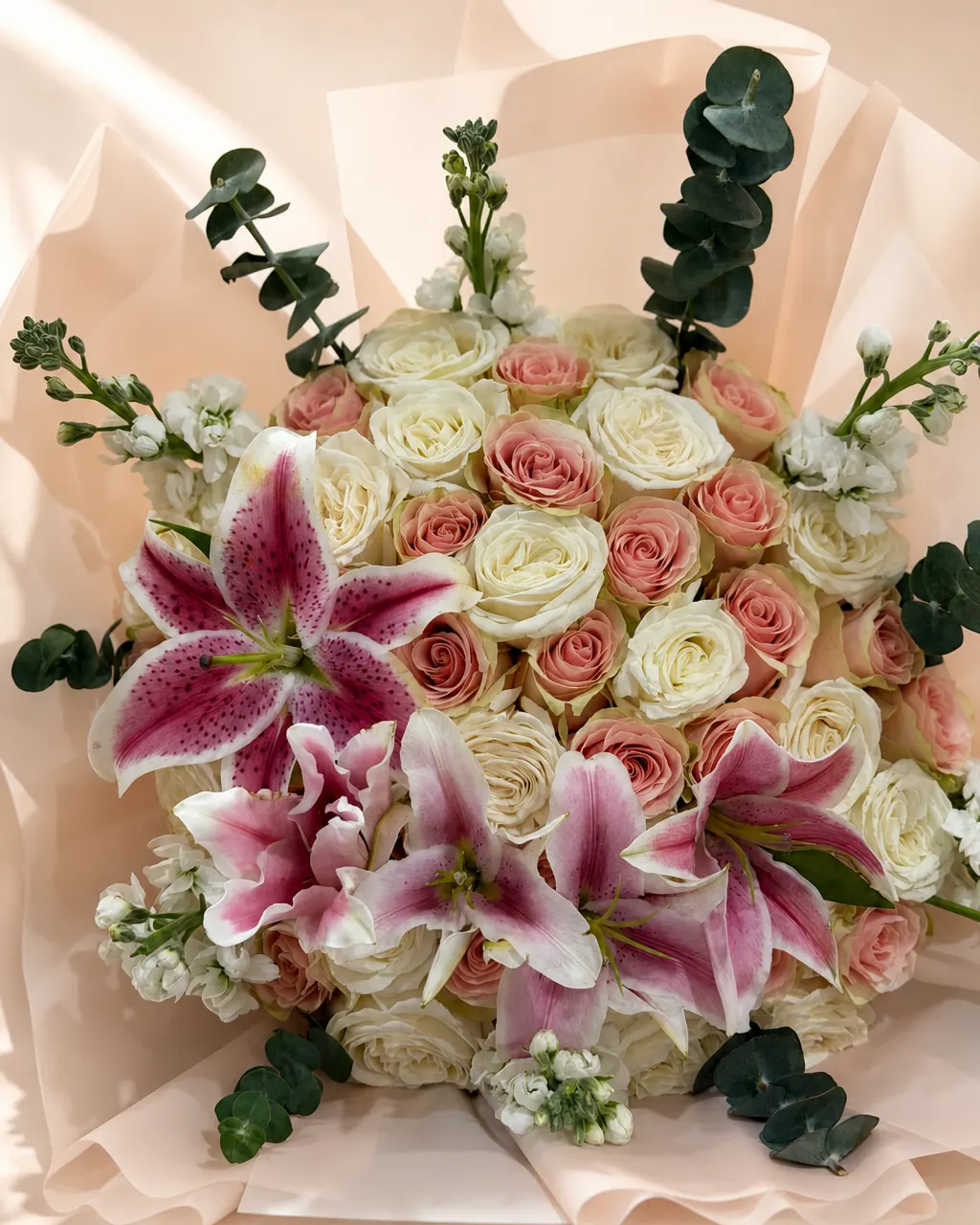 Peach Chiffon: 50 pink and white roses with lilies and eucalyptus, photographed on a blush backdrop
