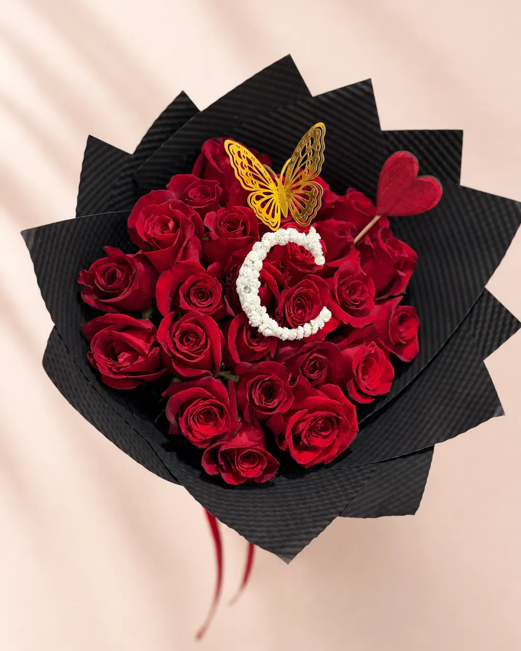 Red Ink: 25 red roses with initial and gold butterfly, photographed on a blush backdrop