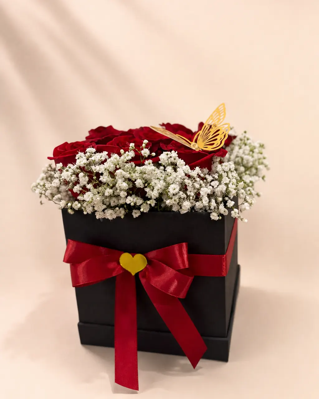Ruby Square: Red roses and baby's breath in a black box, photographed on a blush backdrop