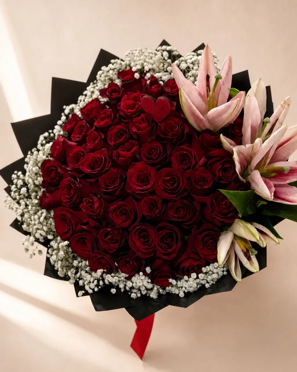 Scarlet Halo: 50 premium red roses with baby's breath rim and lilies, photographed on a blush backdrop