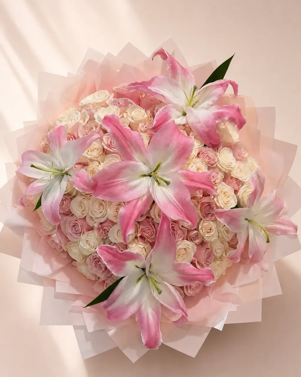 Starry Blush: 50 white and pink roses with a lily topper, photographed on a blush backdrop