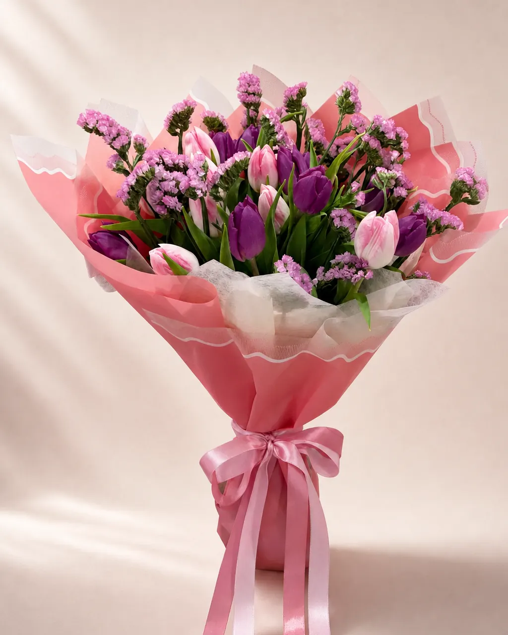 Tulip Armful: 30 mixed tulips in premium wrap, photographed on a blush backdrop
